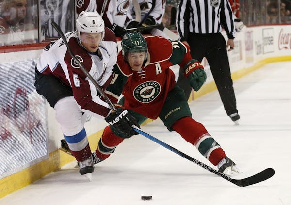 Colorado Avalanche defenseman Erik Johnson (6) and Minnesota Wild left wing Zach Parise (11) vie for the puck during the second period of an NHL hocke