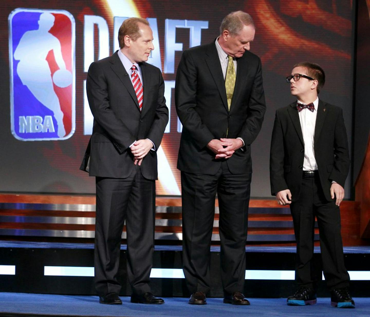 David Kahn, left, general manager of the Minnesota Timberwolves, Kevin O'Connor, center, general manager of the Utah Jazz, and Nick Gilbert, 14, right, the son of Cleveland Cavaliers owner Dan Gilbert, stand on the stage representing the final three teams during the 2011 NBA basketball draft lottery, Tuesday, May 17, 2011 in Secaucus, N.J. The Cavaliers won the lottery.