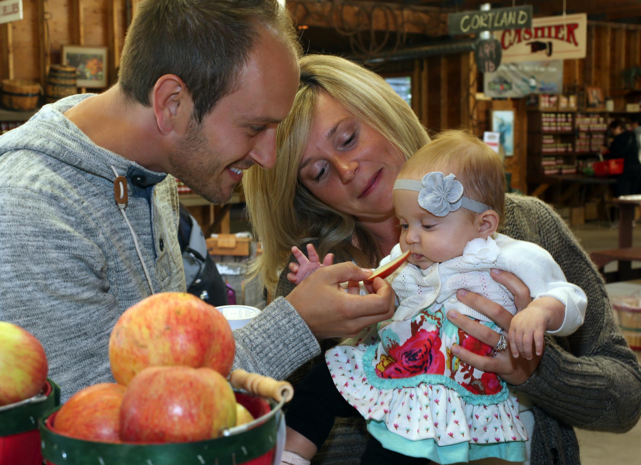 Lonny Sekeres (left) and his wife Krystin Sekeres of Maple Grove gave their 5 monthold daughter, Aria a taste of an apple at Aamodt's Apple Farm at 6428 Manning Av. N. in Stillwater, MN on October 2, 2013. ] JOELKOYAMA‚Ä¢joel koyama@startribune