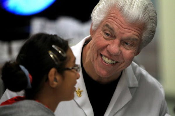 Starkey founder Bill Austin, shown here fitting a girl for hearing aids in 2010.