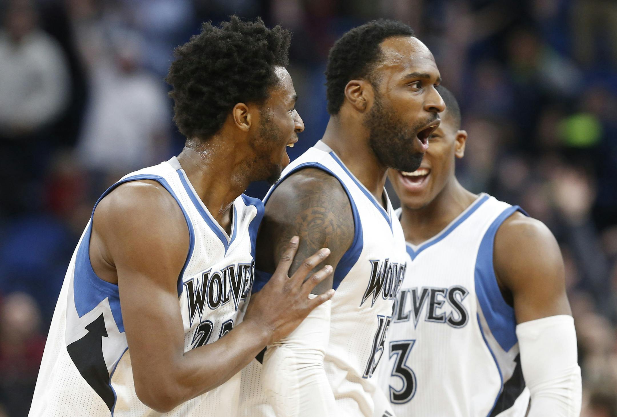 Minnesota Timberwolves' Shabazz Muhammad, center, is congratulated by Andrew Wiggins, left, and Kris Dunn after sinking a half-court shot at the buzzer ending the third quarter during an NBA basketball game against the Orlando Magic, Monday, Jan. 30, 2017, in Minneapolis. The Timberwolves won 111-105 in overtime. (AP Photo/Jim Mone)