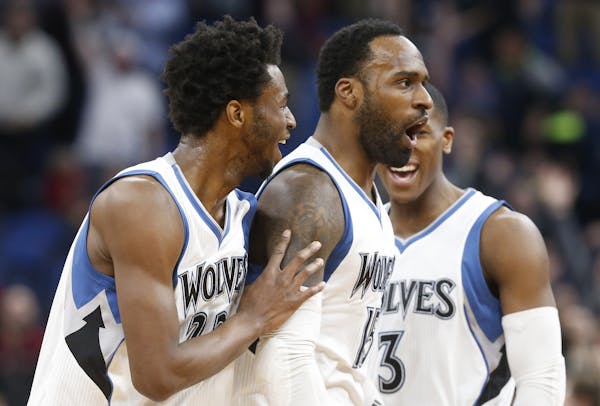 Minnesota Timberwolves' Shabazz Muhammad, center, is congratulated by Andrew Wiggins, left, and Kris Dunn after sinking a half-court shot at the buzze