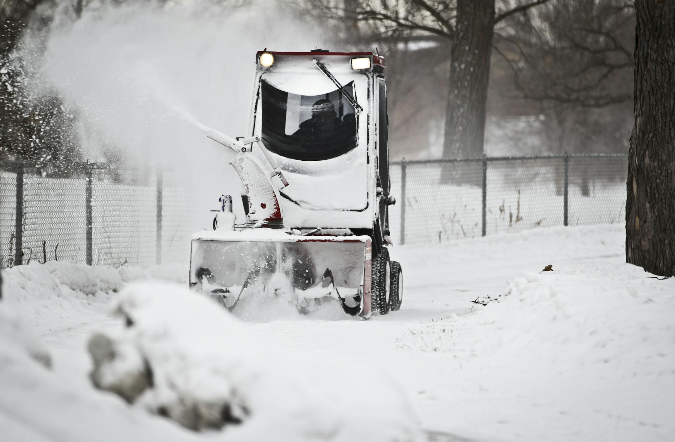 A utilities worker cleared the sidewalk on Columbia Parkway of Monday's early snowfall on Monday, March 4, 2013, Minneapolis, Minn. More snow is expected tonight. ] (RENEE JONES SCHNEIDER * reneejones@startribune.com)