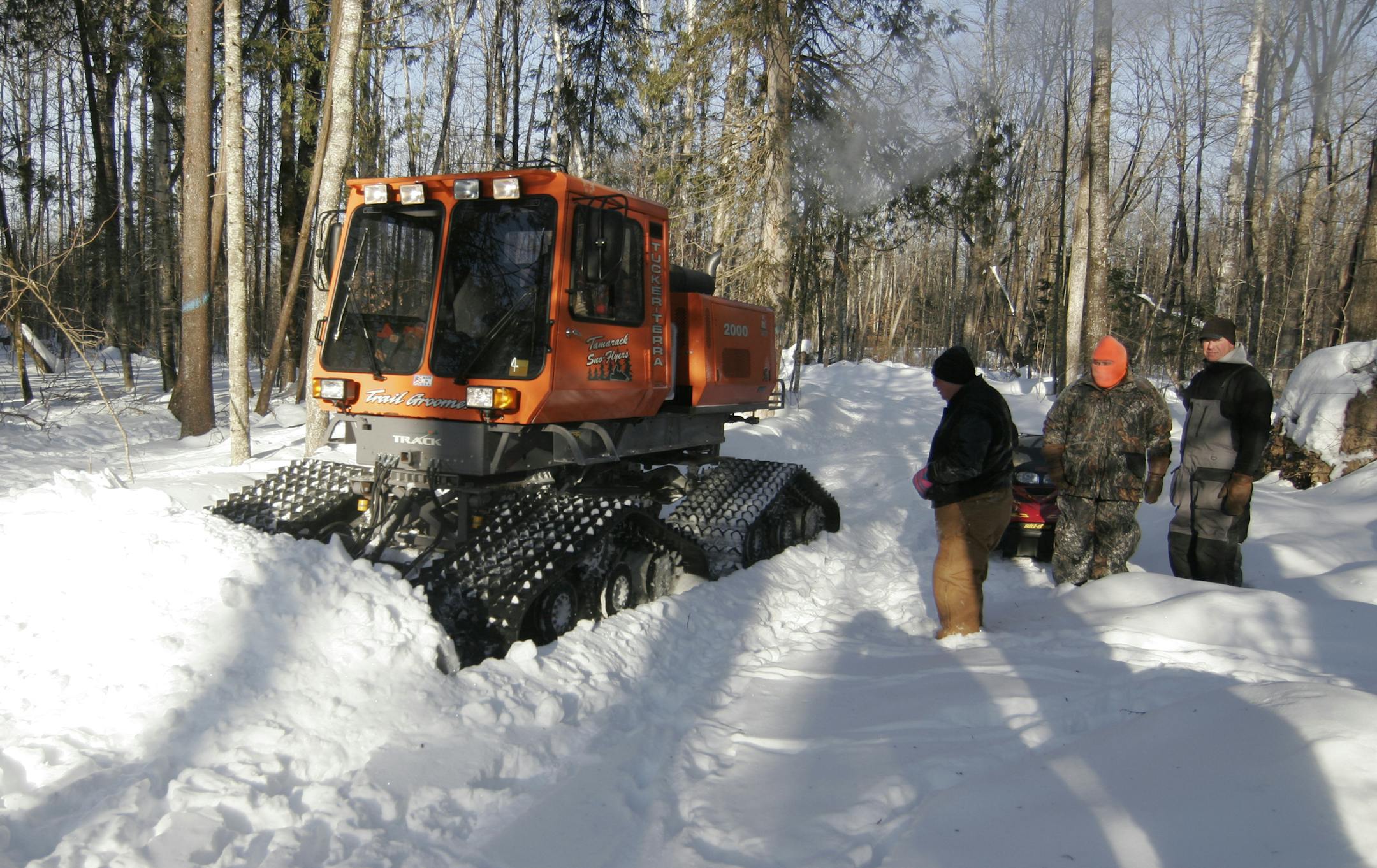 Members of the McGregor chapter of the Minnesota Deer Hunters Association watch Wayne Bobendrier of the Mamarack Sno Flyers snowmobile club plow a trail in the woods near McGregor on Monday where emergency deer feeding will occur. The feeding program, using money from deer license fees, begins this week. Doug Smith/Star Tribune; March 3, 2014.