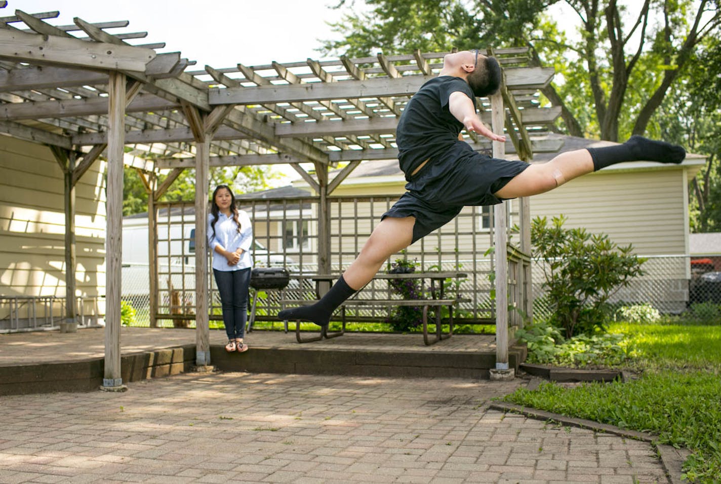 Dmitri Moua of Roseville practices in his back yard while his mom Boa watches. loves to dance and is on his school's dance team in Minnesota. Moua isn't allowed to dance competitively in Minnesota because of his gender.