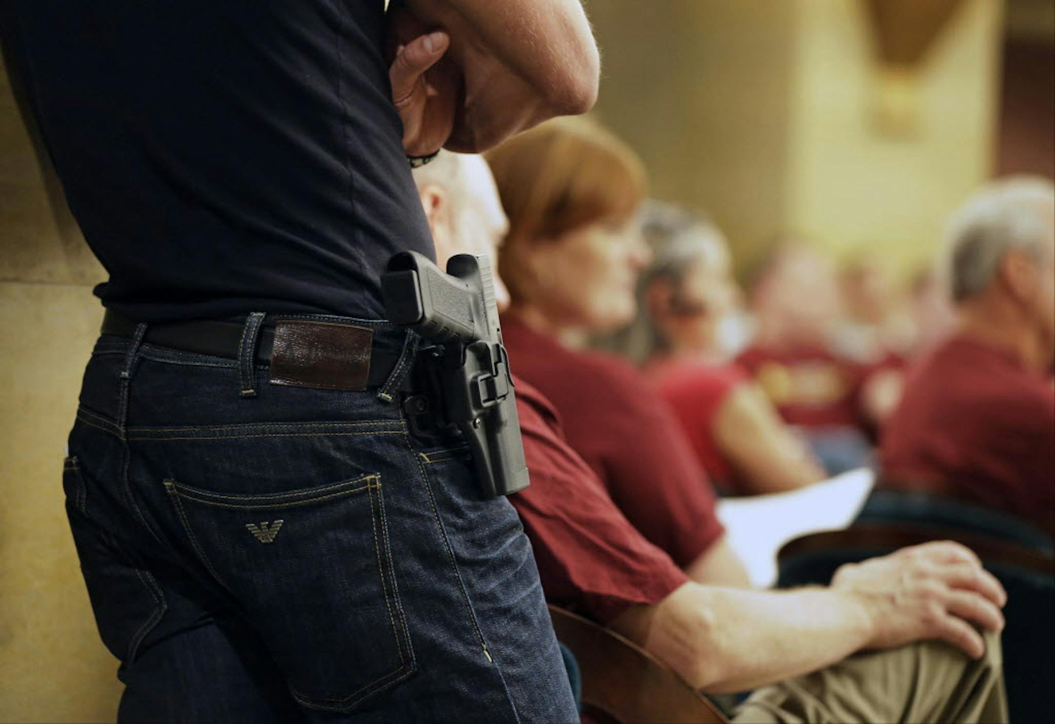 Aug 20, 2013: A Glock handgun is holstered on the side of Kristopher Kranz of Bloomington, as he listens to a legislative committee in St. Paul, during debate on whether Minnesota's rules for carrying a gun in the State Capitol need revising.