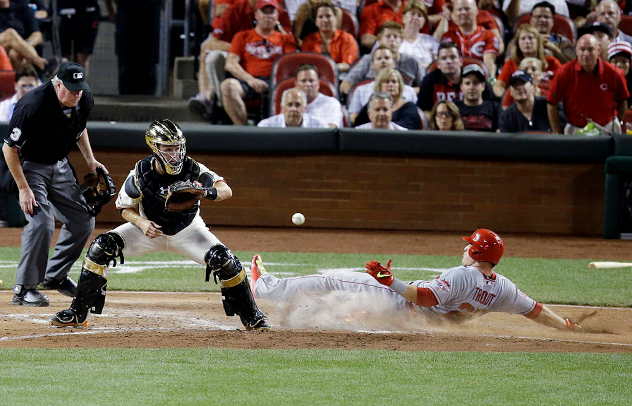 American League's Mike Trout, of the Los Angeles Angels, scores on a hit by American League's Prince Fielder, of the Texas Rangers, while National League catcher Buster Posey, of the San Francisco Giants, covers home during the fifth inning of the MLB All-Star baseball game, Tuesday, July 14, 2015, in Cincinnati.