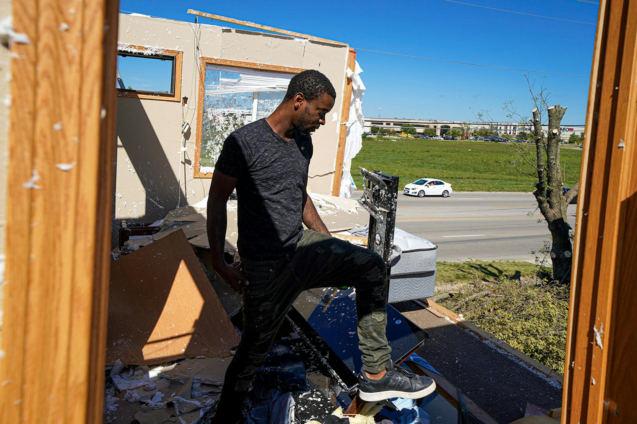 Dennis Muhammad looked over what was left of his bedroom and the traffic below. When the storm hit, he and cousin Andre Moren hunkered down in their apartment while the derecho passed, taking away most of the walls and roof of their home.