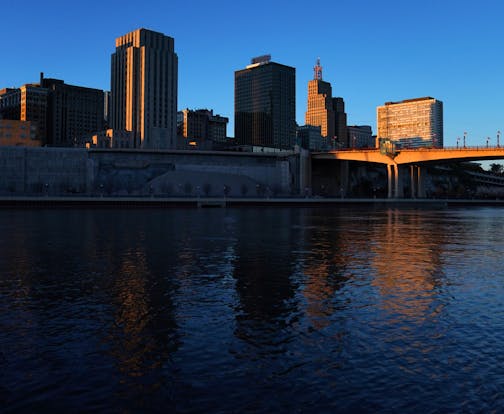 The setting sun illuminated the St. Paul skyline, with city hall on the left, as seen from Harriet Island Park.