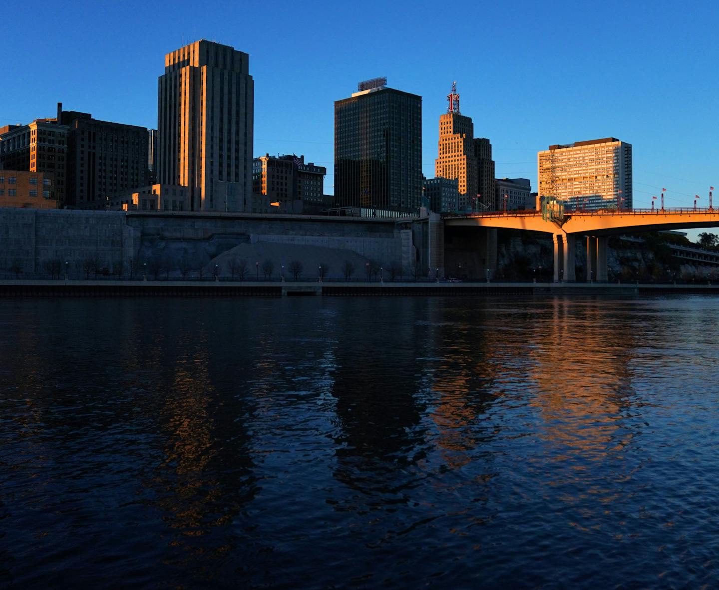 The setting sun illuminated the St. Paul skyline, with city hall on the left, as seen from Harriet Island Park.