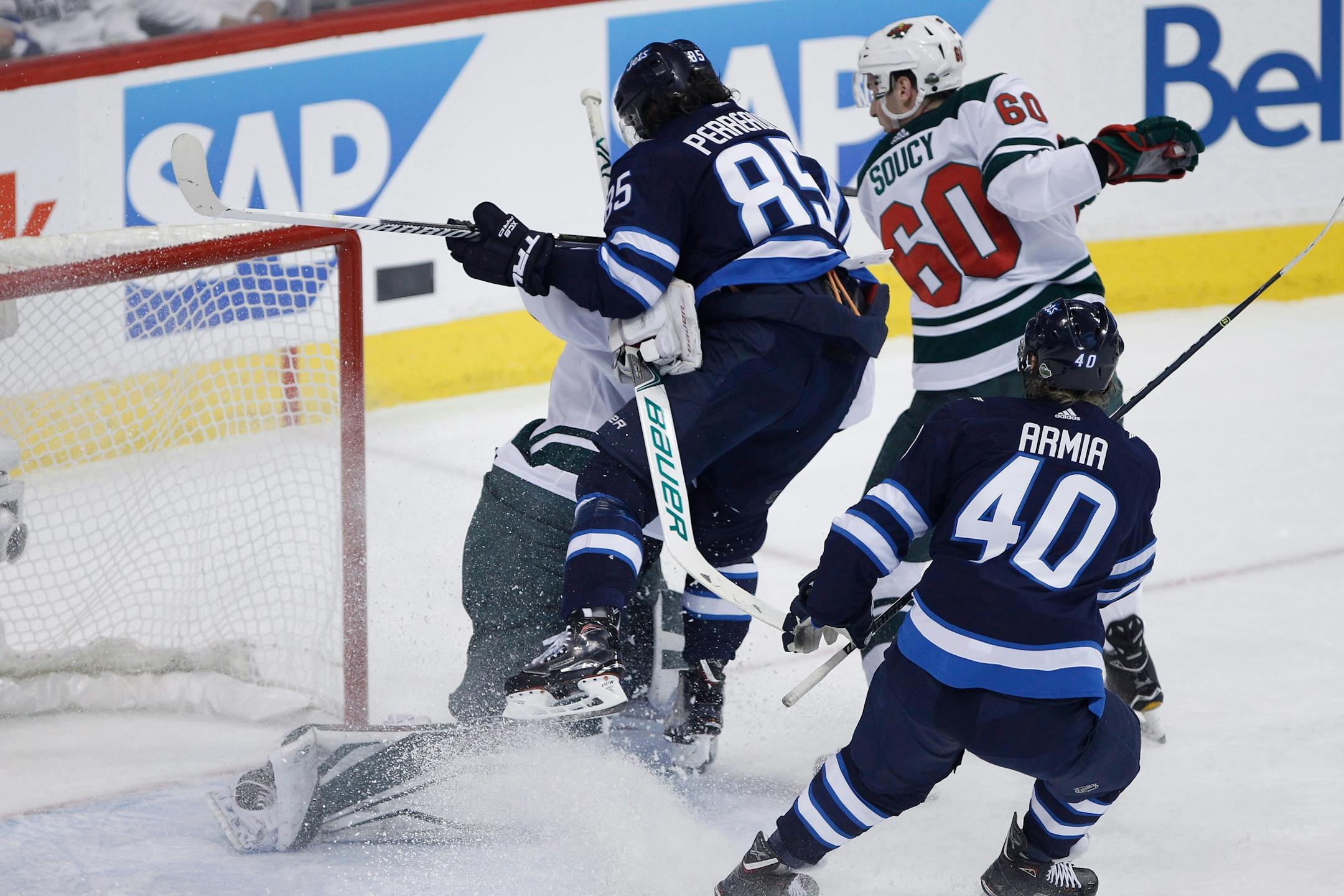 Winnipeg Jets' Mathieu Perreault (85) collides with Minnesota Wild goaltender Devan Dubnyk (40) as Carson Soucy (60) defends. while Jets' Joel Armia (40) looks for the puck during the first period of Game 1 in an NHL hockey first-round playoff series Wednesday, April 11, 2018, in Winnipeg, Manitoba.