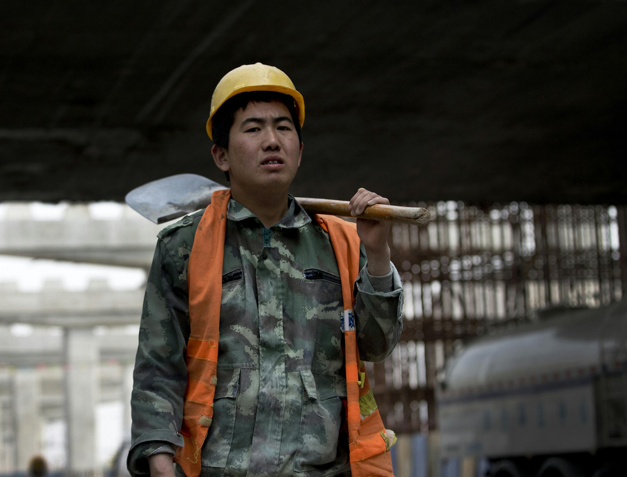 A worker prepares to construct a city highway which is under construction in Beijing Monday, April 15, 2013. China's economic growth slowed unexpectedly in the first three months of the year, fueling concern about the strength of its shaky recovery. The world's second-largest economy grew by 7.7 percent over a year earlier, down from the previous quarter's 7.9 percent, the government reported Monday. (AP Photo/Andy Wong) ORG XMIT: MIN2013042214543354