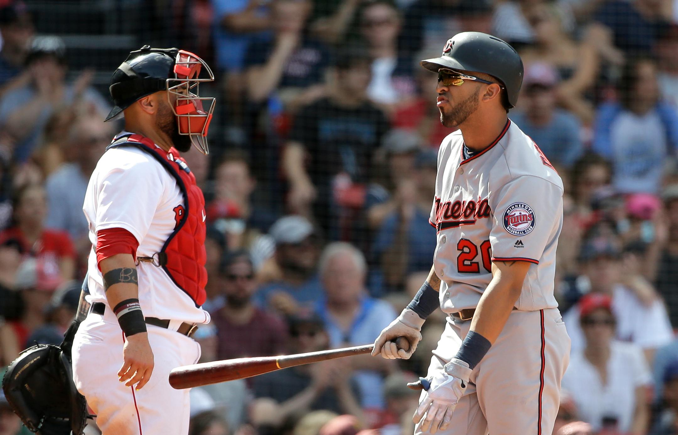 The Twins' Eddie Rosario, right, grimaced after striking out swinging as Red Sox catcher Sandy Leon looked on in the ninth inning Sunday at Fenway Park.
