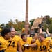 Carleton football players celebrated with their Book of Knowledge trophy after beating Macalester on Saturday in Northfield.