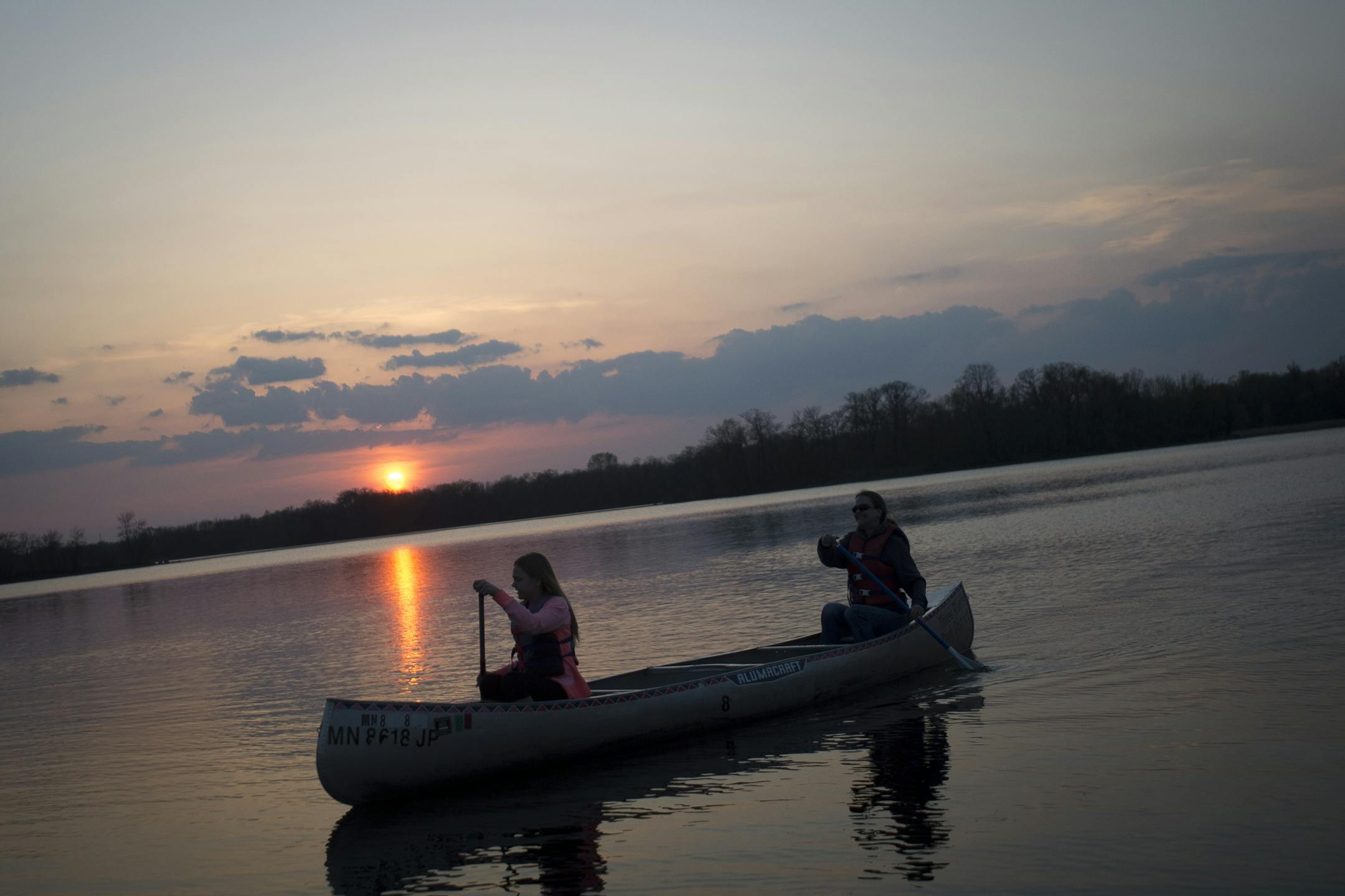 Jessica Krocak and her mother, Ann Krocak, canoe across Cleary Lake at sunset on Friday night. ] (Aaron Lavinsky | StarTribune) aaron.lavinsky@startribune.com Three Rivers Parks District has figured out the full moon is a time of celebration. They offer some kind of night excursion for every full moon. This spring and summer it's canoeing. We photographed an hour-long canoe trip on Friday, May 1, 2015 at Cleary Lake.