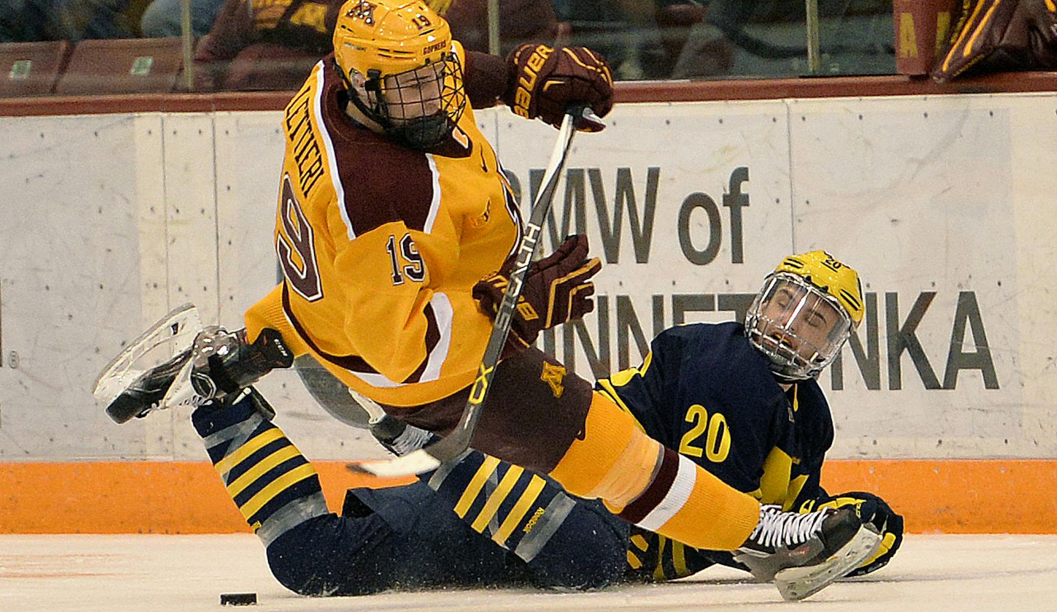 Michigan's Cooper Marody causes Minnesota's Vinni Lettieri to fall to the ice during the third period of the second game in the home series Friday, Feb. 26 at Mariucci Arena. Minnesota right wing Hudson Fasching's goal less than one minute into the overtime period seals the 3-2 victory for the Gophers. ] (SPECIAL TO THE STAR TRIBUNE/BRE McGEE) **Hudson Fasching (not pictured, Minnesota), Vinni Lettieri (MN, 19), Cooper Marody (MI, 20)