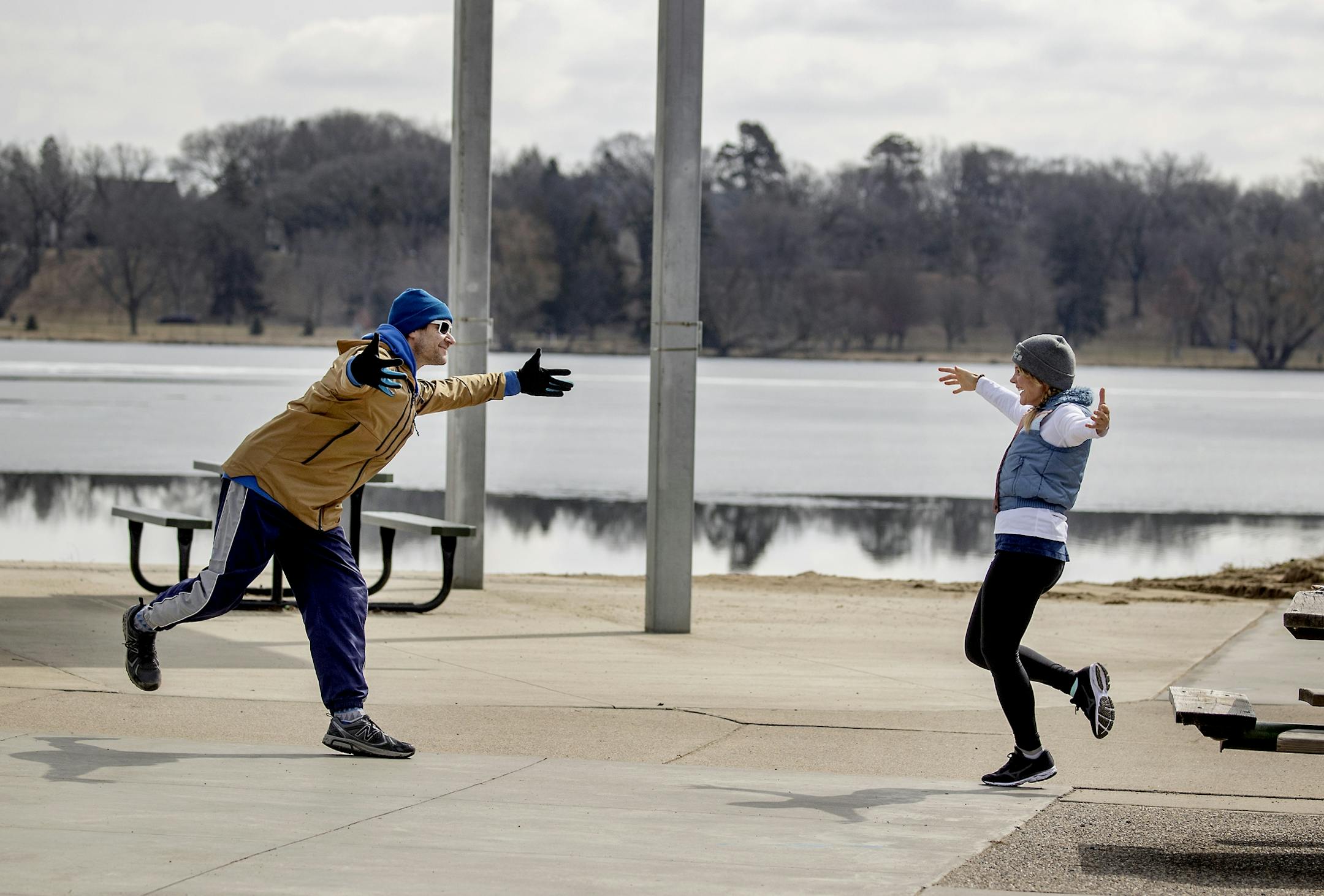 Brian Zirngible said goodbye to his friend Mary Bue, cq, with an "air hug" after they ran into each other at Lake Nokomis, Thursday, March 26, 2020. Zirngible, cq, and Bue, who are musicians, had not seen each other for three months.