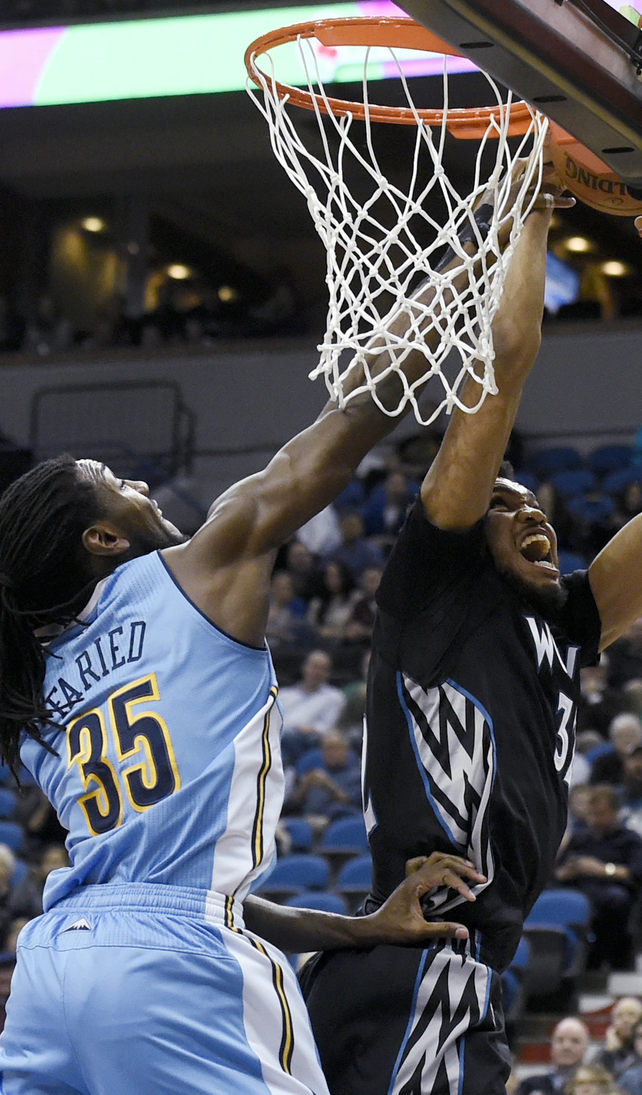 Denver Nuggets forward Kenneth Faried (35) blocks a shot by Minnesota Timberwolves center Karl-Anthony Towns (32) during the first quarter of an NBA basketball game Tuesday, Dec. 15, 2015, in Minneapolis. (AP Photo/Hannah Foslien)