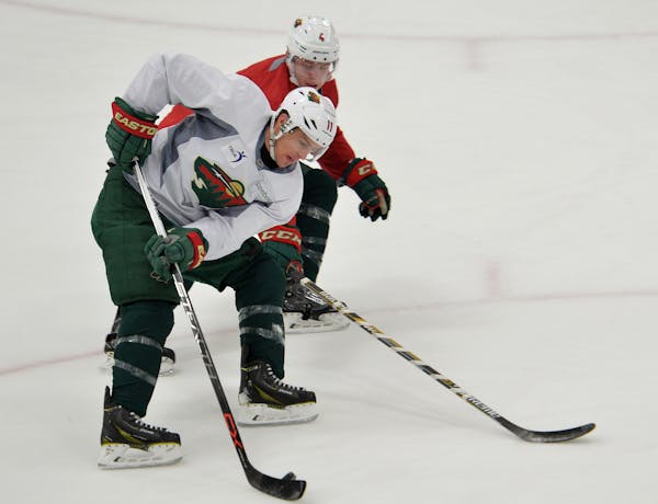 Minnesota Wild left wing Zach Parise battles defender Mike Reilly during a practice drill Sunday, February 14 at Braemer Arena in Edina, the morning a