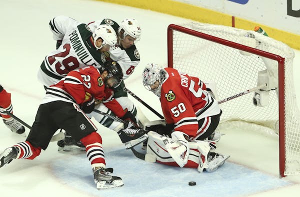 With the goalie pulled, the Wild's Jason Pominville (29) and Mikael Granlund (64) tried to stuff the puck past Chicago Blackhawks goalie Corey Crawfor