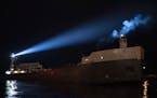 The Victory illuminated its spotlight as it pushed the barge Maumee into the Duluth Harbor on Tuesday night.
