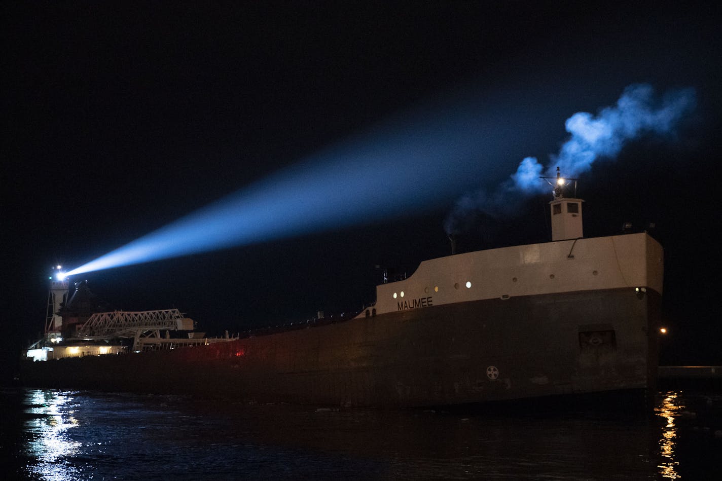 The Victory illuminated its spotlight as it pushed the barge Maumee into the Duluth Harbor on Tuesday night.