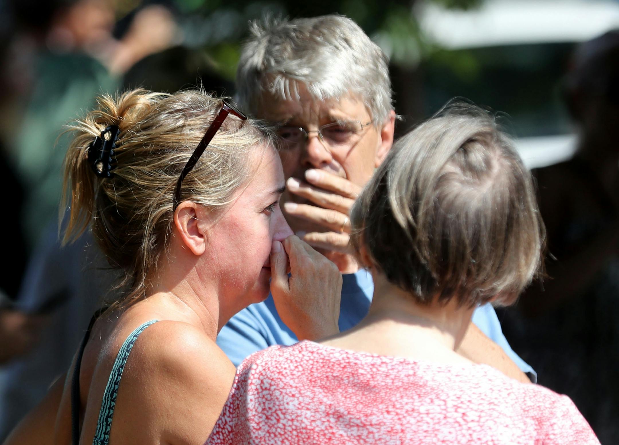 Former Minnehaha Academy employees Elizabeth Van Pilsum, left, who worked at the school for 20 years until 2015, and Rick Olson, middle, a former Spanish teacher whose two children graduated from the school, react after the explosion at Minnehaha Academy on Wednesday, Aug. 2, 2017, in Minneapolis. "My friends are in there," Van Pilsum said.