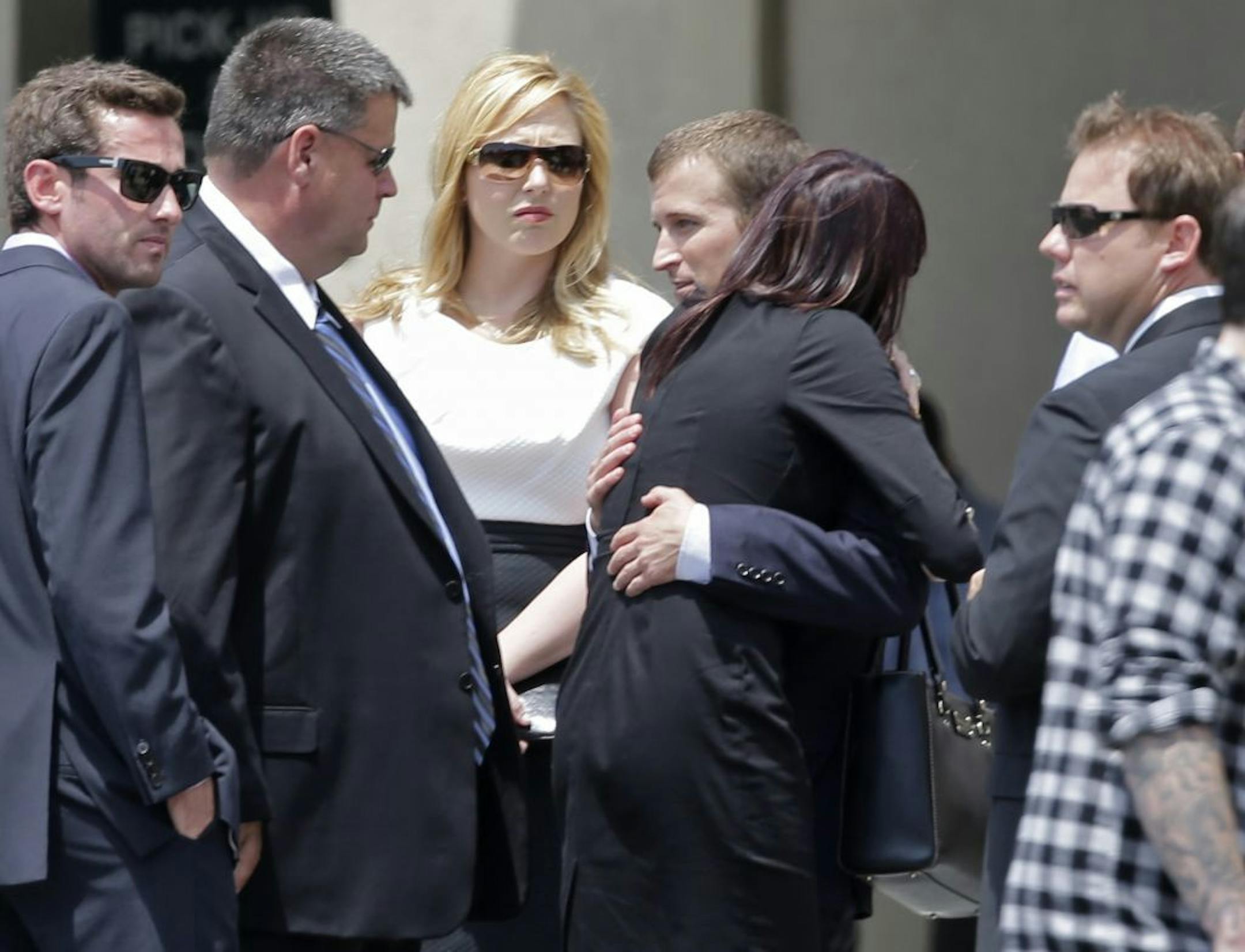 NASCAR driver Kasey Kahne, center, hugs an unidentified woman as they arrive for the funeral of driver Jason Leffler at Grace Covenant Church in Cornelius, N.C., Wednesday, June 19, 2013. Leffler lost his life in a racing accident last week.