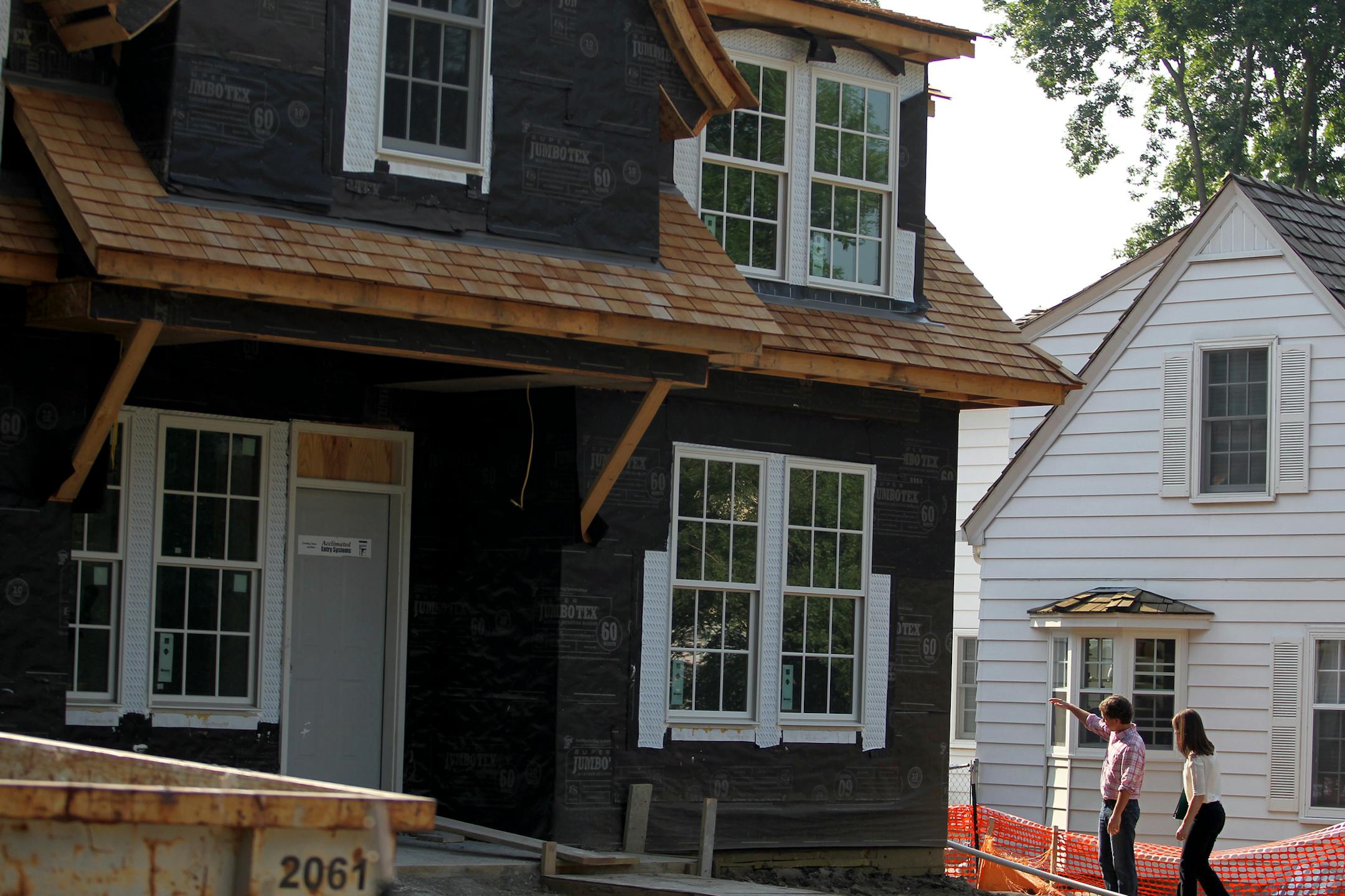Residential Redevelopment Coordinator for the City of Edina, Cindy Larson, speaks with Scott Busyn, the owner of Great Neighborhood Homes at a new home construction site in Edina, Minn., on Thursday, July 11, 2013. Larson is a mediator between home builders and neighbors. "My job is part construction, part counselor," she said. ] (ANNA REED/STAR TRIBUNE) anna.reed@startribune.com (cq)