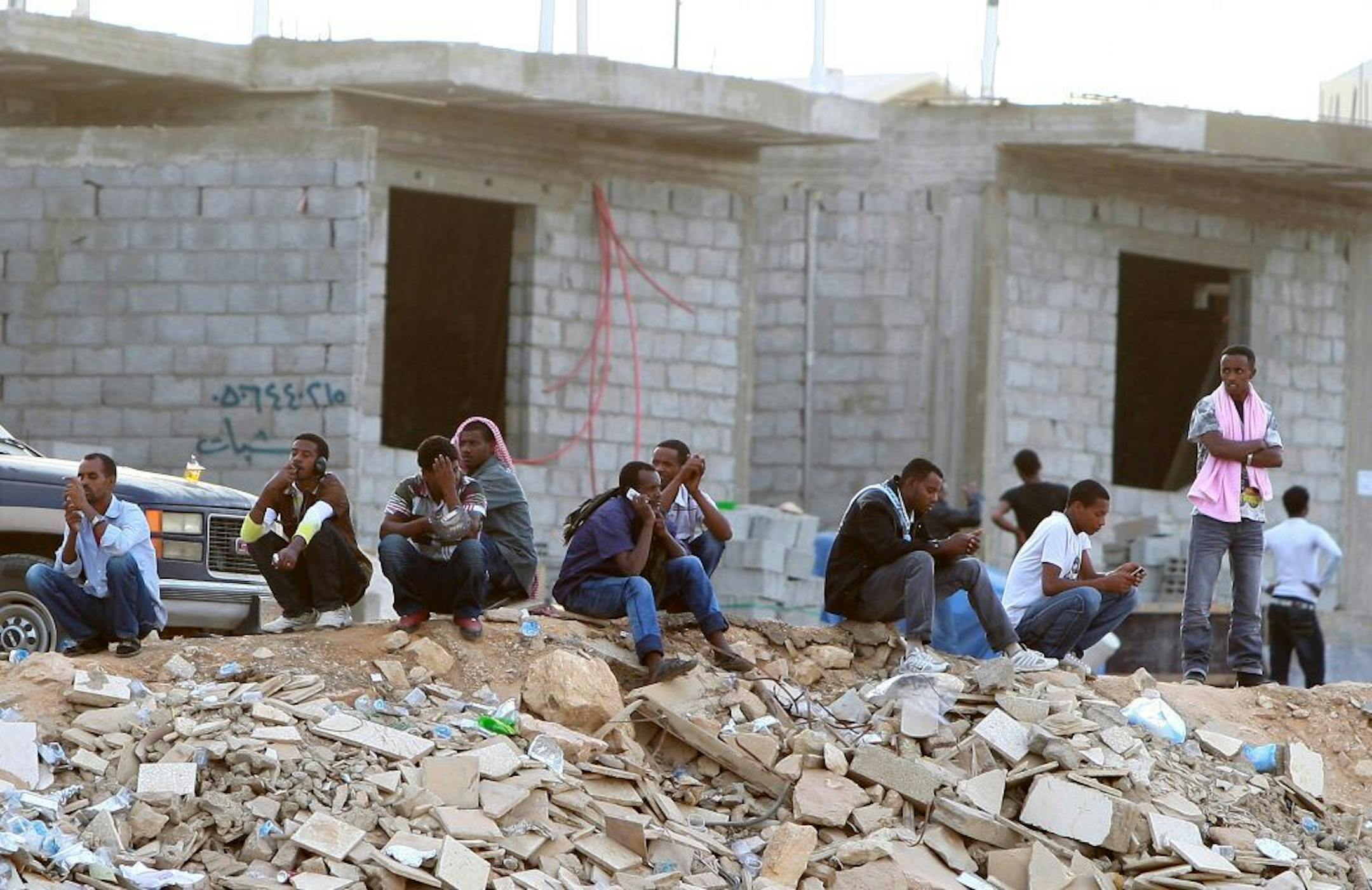 In this Wednesday, Nov. 13, 2013 photo, Ethiopians gather as they wait to be repatriated in Manfouha, southern Riyadh, Saudi Arabia.