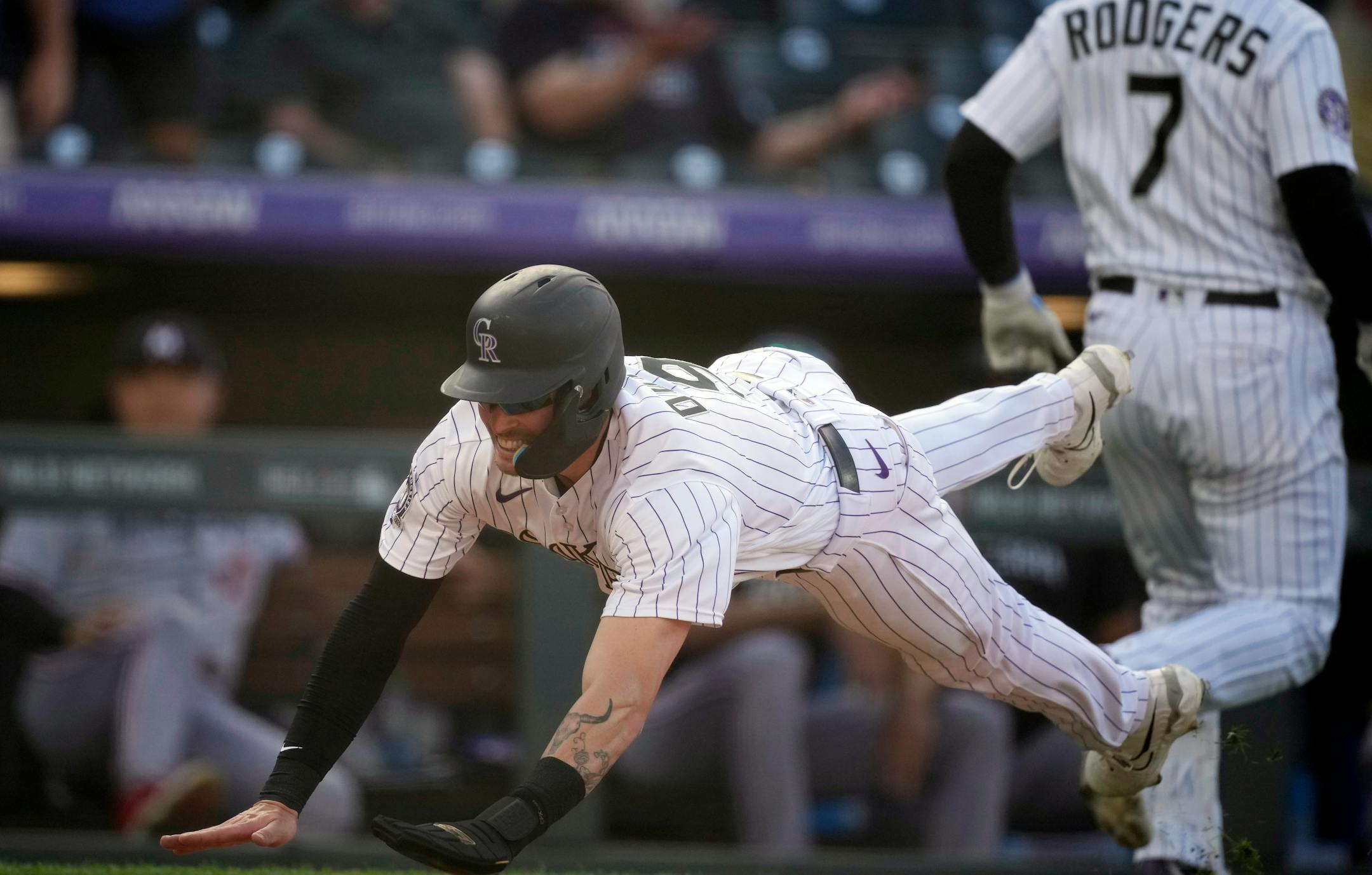 Colorado Rockies' Brenton Doyle, left, slides safely into home plate to score the winning run on a wild pitch by Minnesota Twins relief pitcher Jordan Luplow in the 11th inning of a baseball game Sunday, Oct. 1, 2023, in Denver. (AP Photo/David Zalubowski)