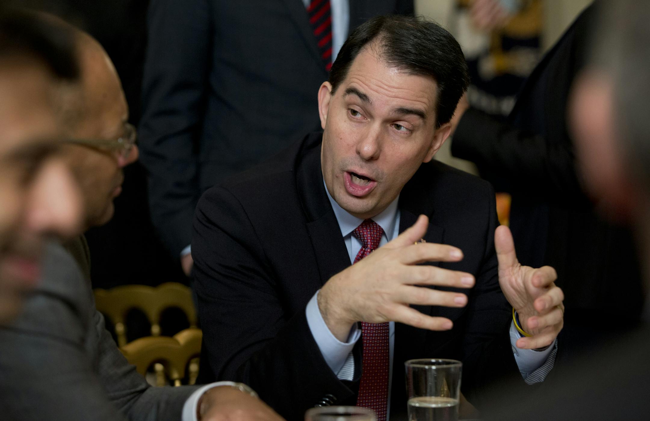 Wisconsin Gov. Scott Walker talks to people at his table before President Barack Obama arrives to speaks to members of the National Governors Association, Monday, Feb. 23, 2015, in the State Dining Room of White House in Washington. As they gather in Washington, many of the nation's Republican governors are blaming President Barack Obama for a budget standoff that threatens a potential Department of Homeland Security shutdown. (AP Photo/Carolyn Kaster)