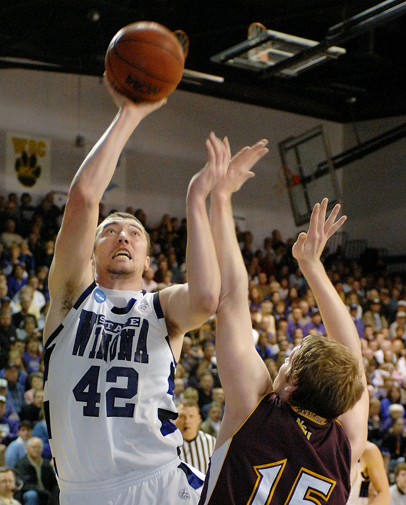 Winona State's John Smith takes a shot over Northern State's Levi Hamilton in the NSIC tournament championship game March 8 2008, in Winona, Minn. Smith's 17.7 points per game leads the Warriors.