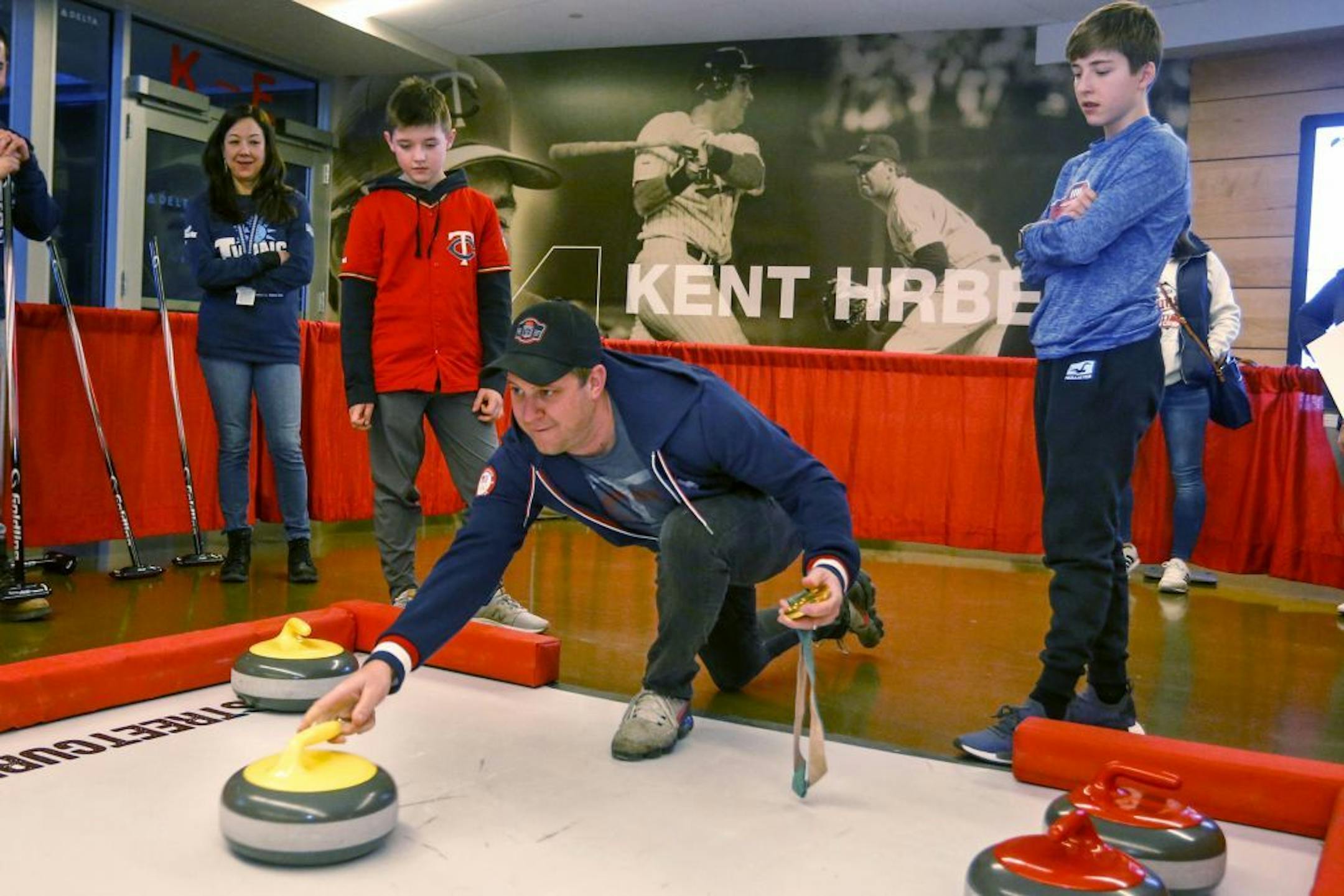 Olympic gold medalist in curling John Shuster shows young fans how to curl while holding his medal during the Minnesota Twins baseball team's TwinsFest, Friday, Jan. 25, 2019, in Minneapolis.