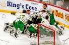 Edina players make the traditional heap to celebrate their Class 2A hockey championship Saturday.