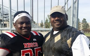 Deveall McClendon, left, with his father, Derek McClendon, while wearing his football uniform in college. Deveall was killed over a year ago in a driv