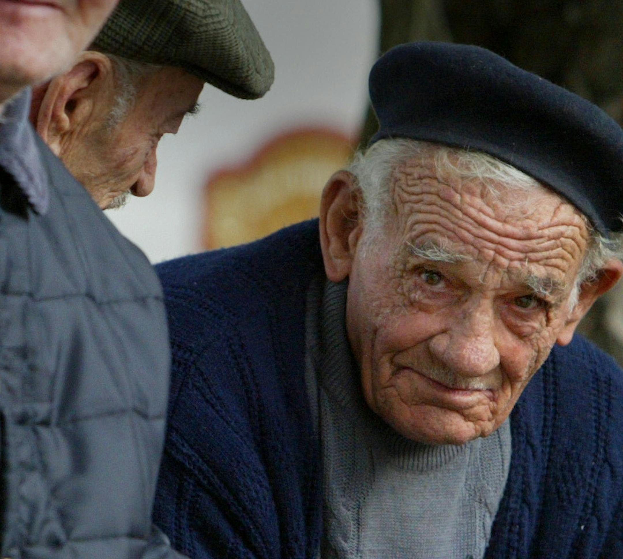 Northern, Italy 10/2003-- Elderly men gathered on a bench late one afternoon watching the traffic go byin their small village.