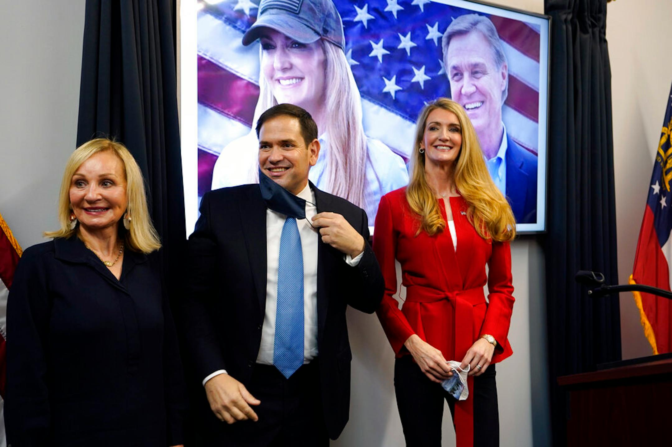 Sen. Marco Rubio, R-Fla., stands with Georgia Republican candidate for Senate Kelly Loeffler, right, and Bonnie Perdue, wife of Sen. David Perdue, R-Ga., after a campaign rally Wednesday, Nov. 11, 2020, in Marietta, Ga. (AP Photo/John Bazemore)