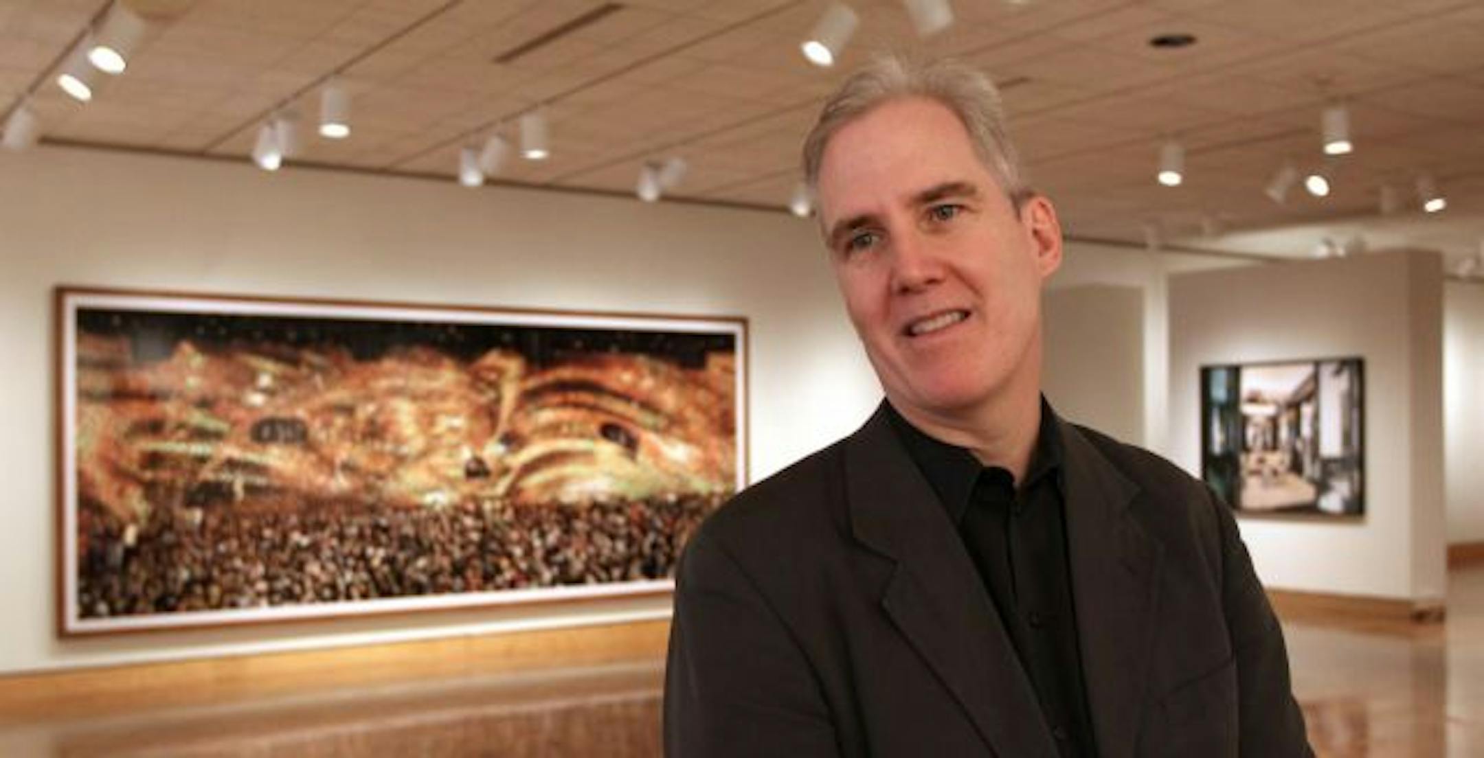 German photographer Andreas Gursky recorded a crowd of young, buff and beautiful people partying under a golden honeycomb canopy at the Cocoon Club in Frankfurt. The monumental photo hangs behind curator David Little at the Minneapolis Institute of Arts.
