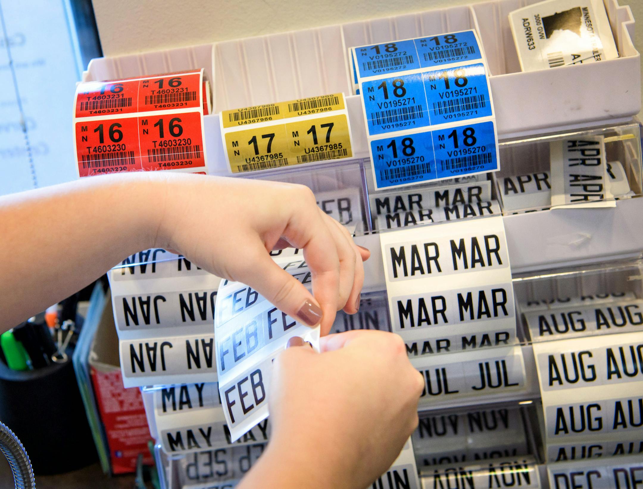 Miranda Sylvander helped Jacob Leverenz get a new set of vehicle license plates and tabs at the Carver County Service Center in Chanhassen. ] GLEN STUBBE * gstubbe@startribune.com Monday, August 22, 2016 Driv-thru service centers are popping up in the suburbs as a way to shortern wait time and ease up conjestion for tab renewals.