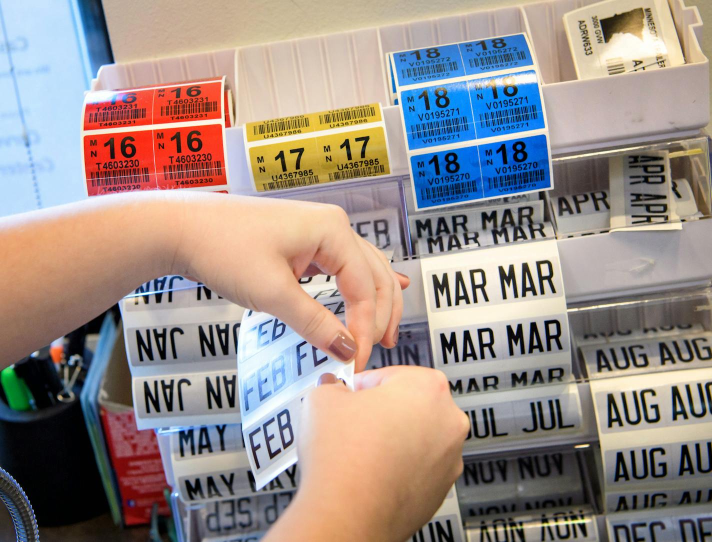 Miranda Sylvander helped Jacob Leverenz get a new set of vehicle license plates and tabs at the Carver County Service Center in Chanhassen. ] GLEN STUBBE * gstubbe@startribune.com Monday, August 22, 2016 Driv-thru service centers are popping up in the suburbs as a way to shortern wait time and ease up conjestion for tab renewals.