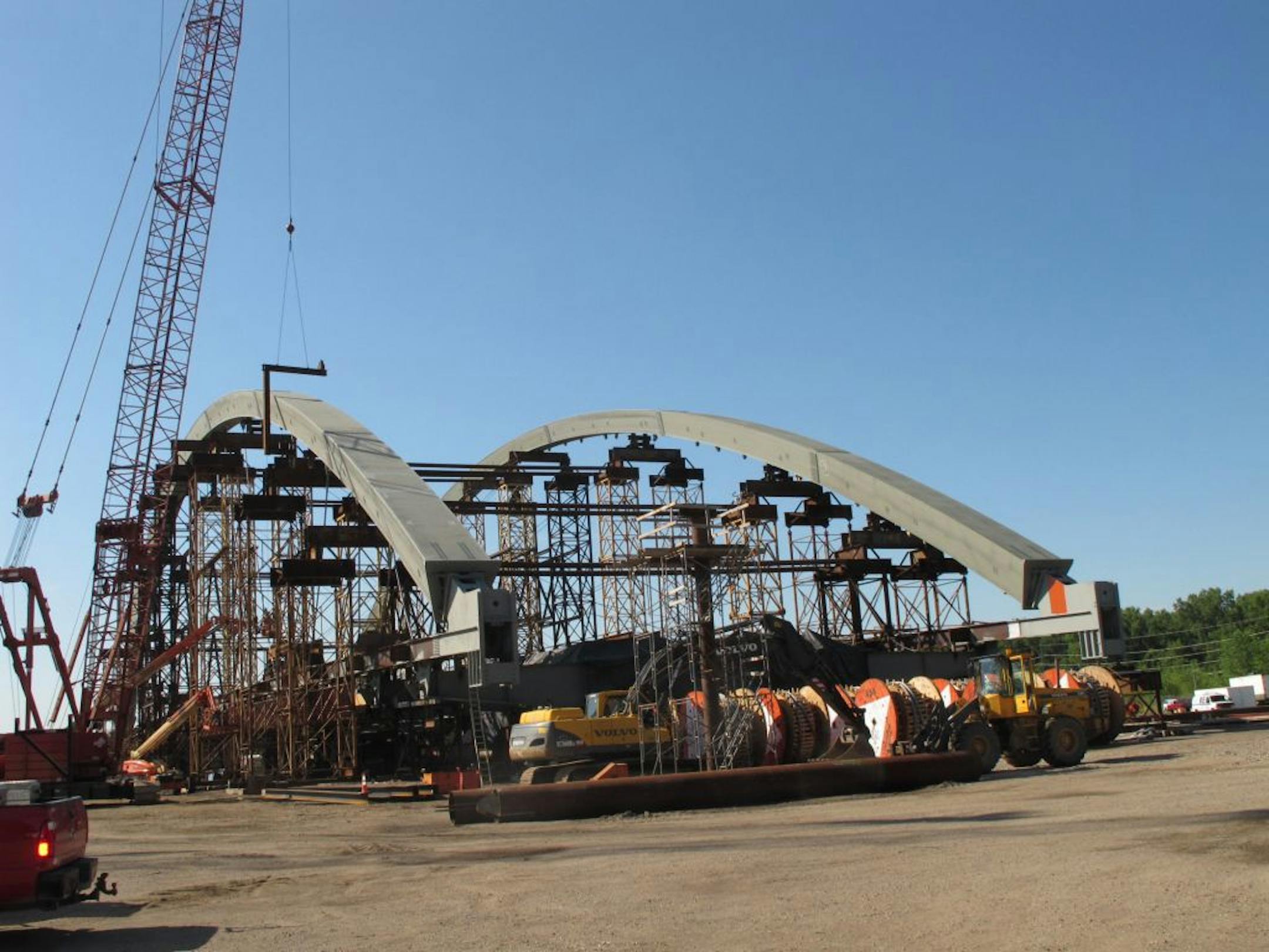 The twin arches are up for the new Hastings bridge across the Mississippi River. All the scaffolding will be removed when motorized transporters roll the 3,300-ton structure onto barges in September so it can be floated into place to complete the main bridge span.