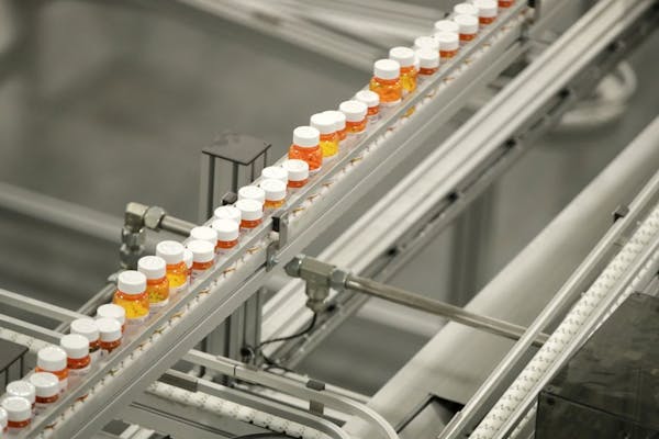 FILE- In this July 10, 2018, file photo bottles of medicine ride on a belt at the Express Scripts mail-in pharmacy warehouse in Florence, N.J. As Demo