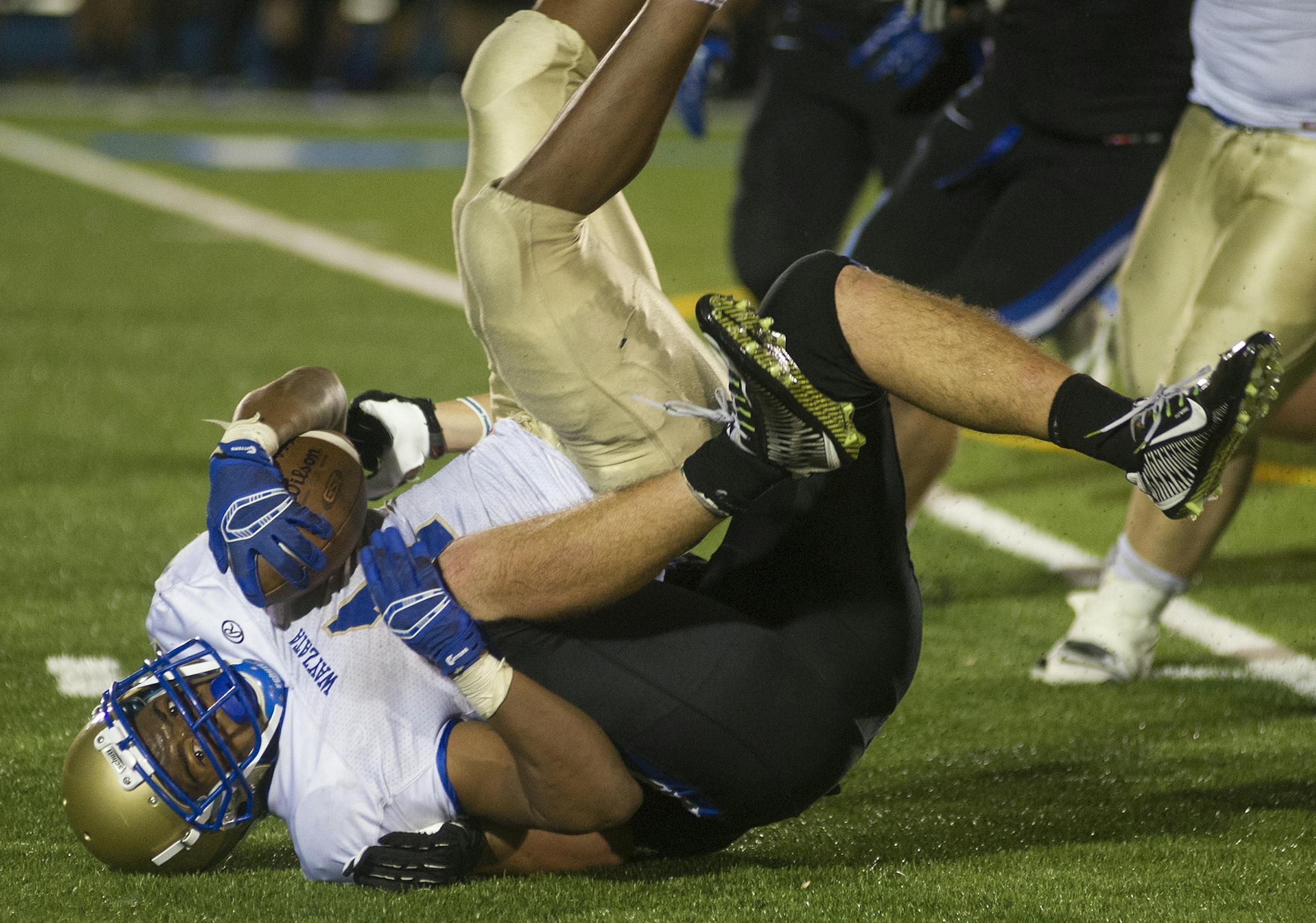 Wayzata's Austin Gordon picks up a first down as he brought down by Minnetonka's Jack Burns Friday, October 24, 2014 during a game against Minnetonka at Minnetonka High School. Wayzata finished ahead 31-28 ending Minnetonka's season and advancing in the playoffs. ] (Matthew Hintz, 102414, Minnetonka)