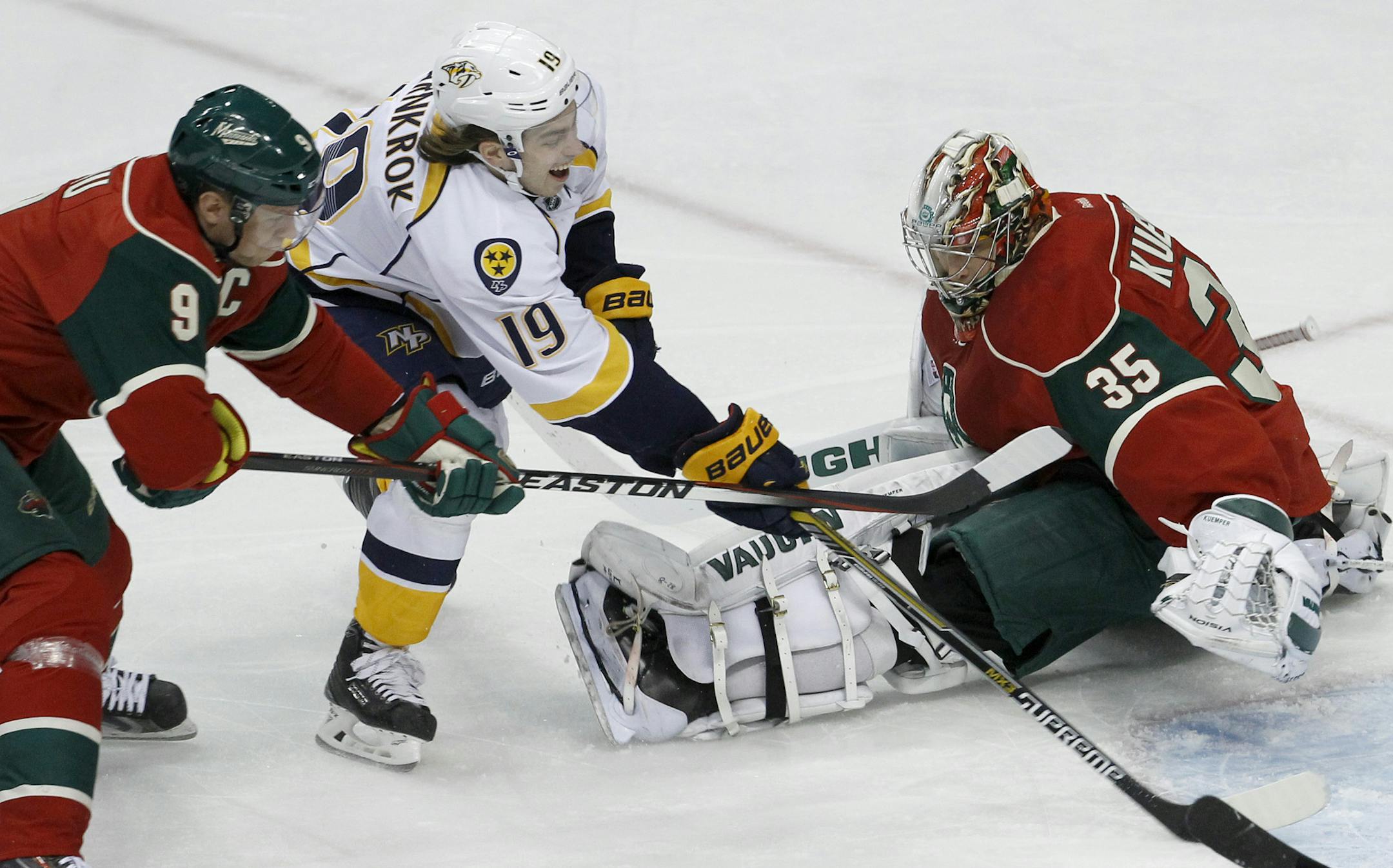 Nashville Predators center Calle Jarnkrok (19), of Sweden, scores on Minnesota Wild goalie Darcy Kuemper (35) as Wild center Mikko Koivu (9), of Finland, tries unsuccessfully to stop him during the first period of an NHL hockey game in St. Paul, Minn., Saturday, Dec. 20, 2014. (AP Photo/Ann Heisenfelt)