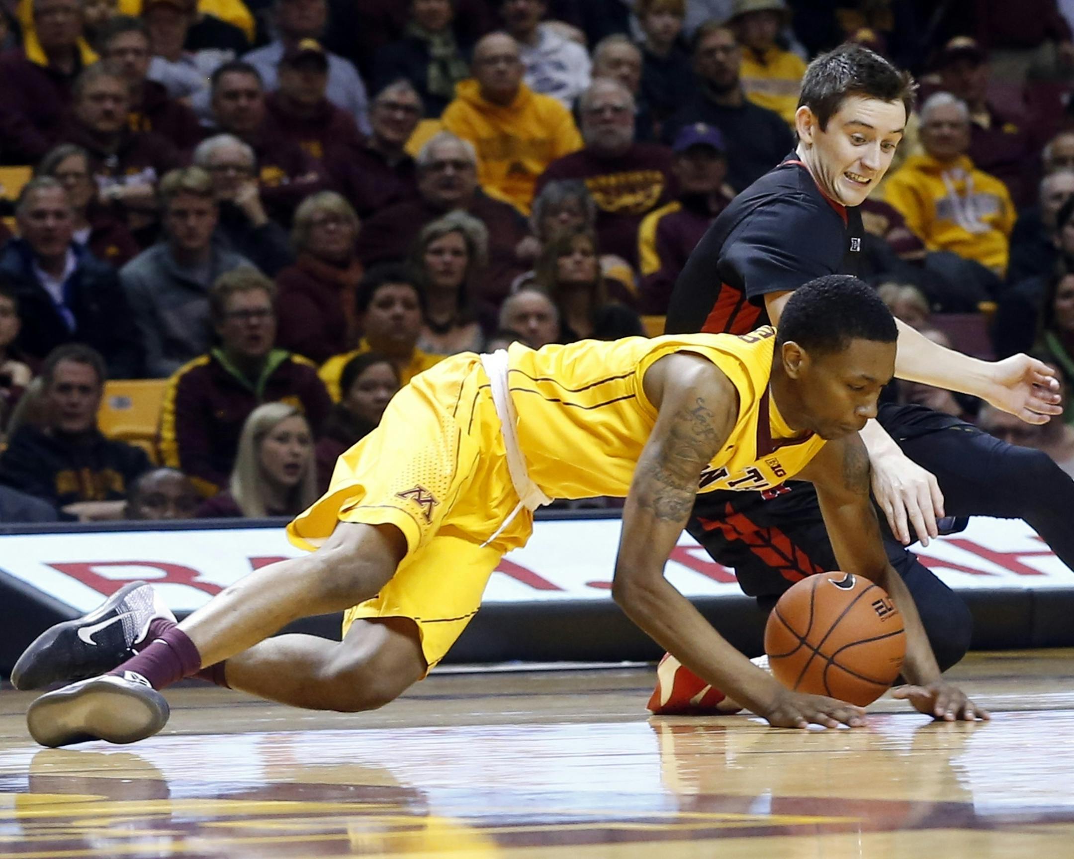 Minnesota's Dupree McBrayer, left, and Rutgers' Justin Goode hit the floor during the first half of an NCAA college basketball game Tuesday, Feb. 23, 2016, in Minneapolis. (AP Photo/Jim Mone)