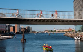 Pedaling over, and paddling under, the Cykelslangen ("Bicycle Snake") bridge in bike-friendly Copenhagen.