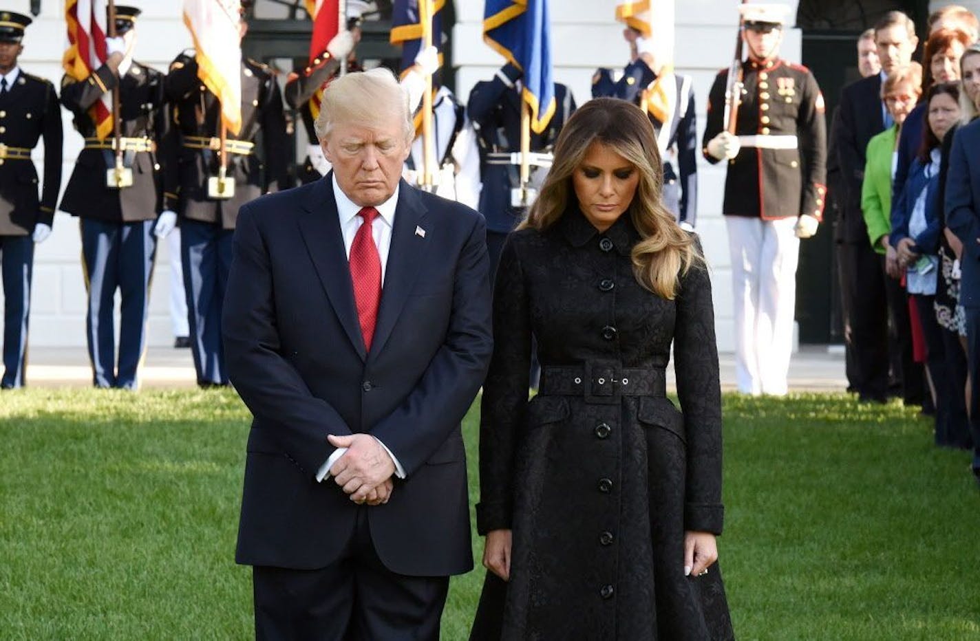 U.S. President Donald Trump and first lady Melania Trump, joined by White House staff, participate in a moment of silence on the 16th anniversary of the Sept. 11 terrorist attacks on the United States, at the White House on Sept. 11, 2017 in Washington, D.C.