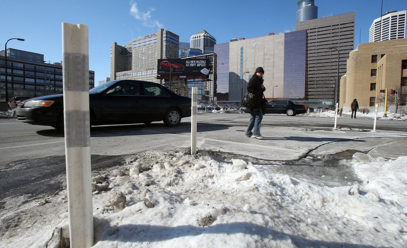 A pedestrian walked across the intersection of 6th Street and Portland Avenue by a "bump out" that extend curb in Minneapolis, MN on February 14, 2014. ] JOELKOYAMA&#x201a;&#xc4;&#xa2;jkoyama@startribune A fatal pedestrian accident near Lake Calhoun comes as Minneapolis is looking for ways to make it safer for pedestrians. One idea that we've all seen pop up recently: so-called "bump outs" that extend curbs so pedestrians are more visible and vehicles have to turn more slowly at intersections. T