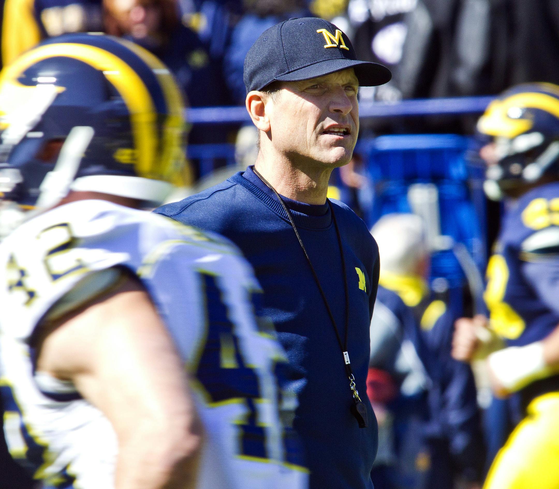 Michigan head coach Jim Harbaugh watches his players as they warm up before a spring NCAA college football game in Ann Arbor, Mich., Saturday, April 4, 2015. (AP Photo/Tony Ding)